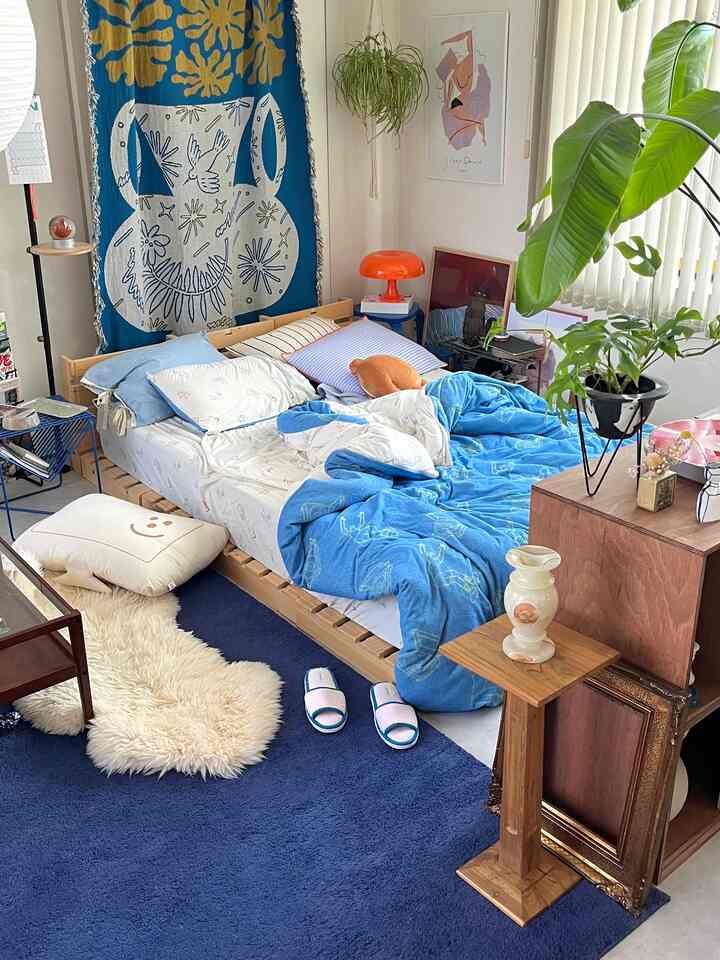 Blue and wood tone bedroom featuring plants and cozy natural elements