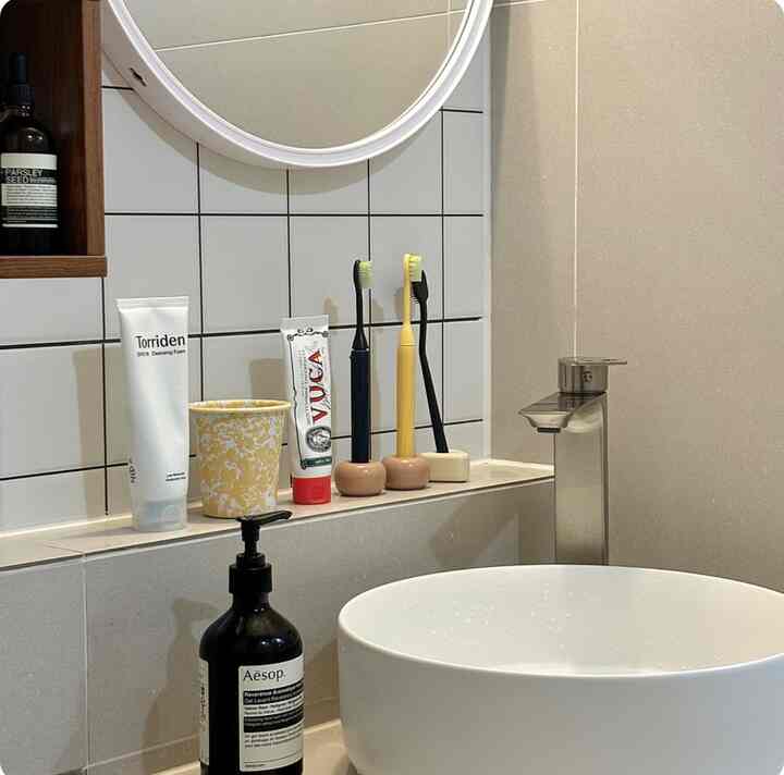Modern dry bathroom in white and gray tones featuring a round sink and American Standard faucet, clean and minimalistic setup