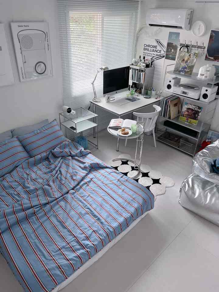 Modern small single household room in white and blue tones featuring a desk and bed with a clean home office setup