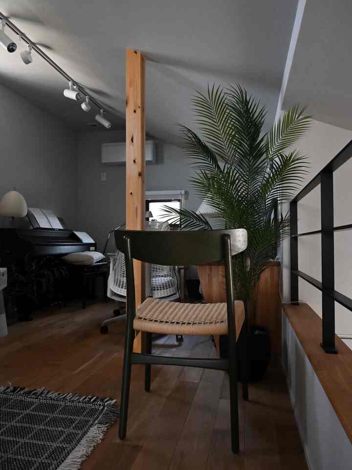 ナチュラルカラーとブラウン調のワークスペース、CH23ダイニングチェアと大型植物が配置された居心地の良い空間