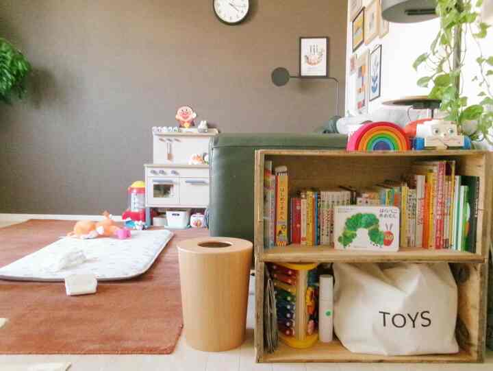 ナチュラルな色調のリビング、りんご箱の玩具収納と子供の遊び道具が整った雰囲気のある空間