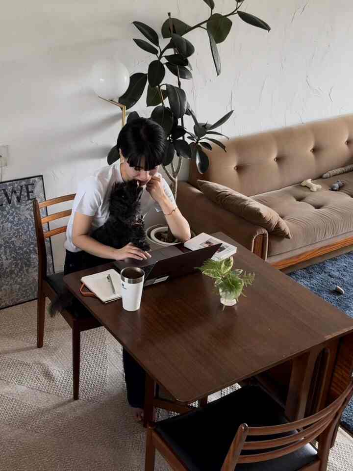 ブラウンとナチュラルカラーのダイニングルーム、ソファとダイニングテーブルが配置された落ち着いたリモートワーク空間