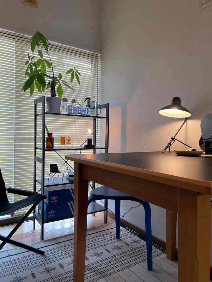 Dining room in black and wood tones featuring a dining table, stool, lounge chair with a cozy atmosphere