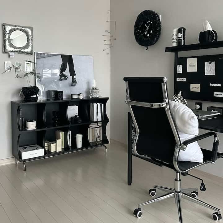 Monotone and black styled study interior featuring a tidy bookshelf, desk, and silent souffle wall clock