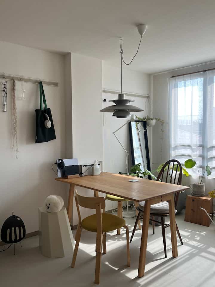 Bright white and wood tone single household home office and dining space featuring pet plush toy and natural light