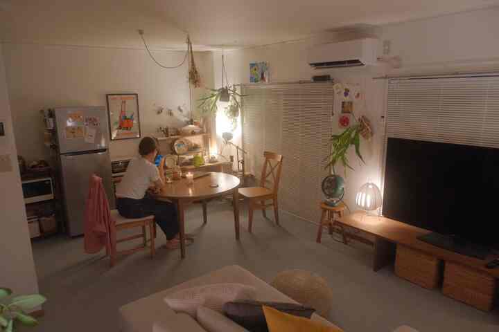 Warm brown-toned living and dining room with wooden furniture and cozy lighting creating a comfortable space
