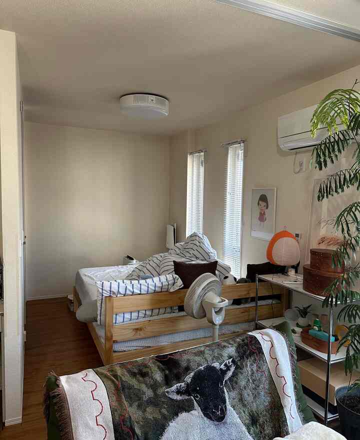 Beige-toned walls and wood-tone bed in bedroom and living space with a slightly cluttered cozy atmosphere