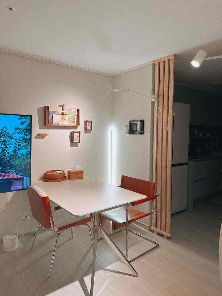 白と茶色のトーンのダイニング、カフェ風の居心地の良い空間にダイニングテーブルと椅子が配置されている