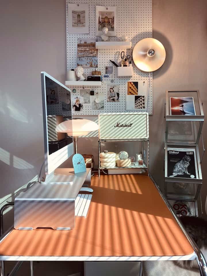 Brown-toned desk with silver monitor stand in remote work home office setting