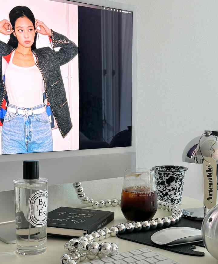 白を基調としたコンパクトなホームオフィス空間、デスク上にアイスコーヒーとシルバーの装飾が配置された清潔感のあるインテリア