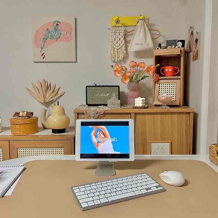 Beige and wood-tone walk-in closet space featuring a round table with tablet stand and Bluetooth keyboard in a simple home office setting