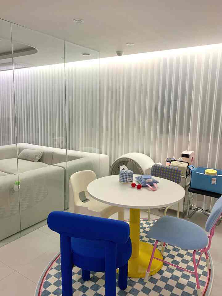 白と黄色、青の色調が調和したダイニングルーム、様々なデザインのテーブルと椅子が配置された清潔で明るい空間