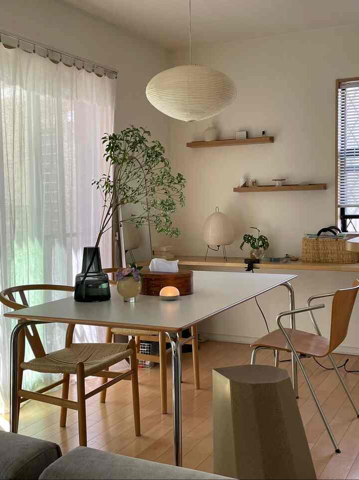 Beige and white toned dining room featuring natural wood furniture and pendant lighting with a calm atmosphere
