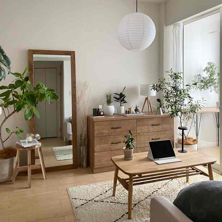 ナチュラルな木目調と白い壁のリビング、木製家具と植物が調和した落ち着いたインテリア