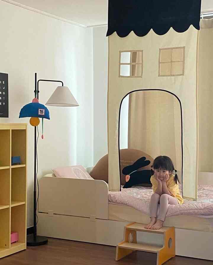 ベージュとホワイトの色調の子供部屋、子供用ベッドと収納が配置された雰囲気のある空間