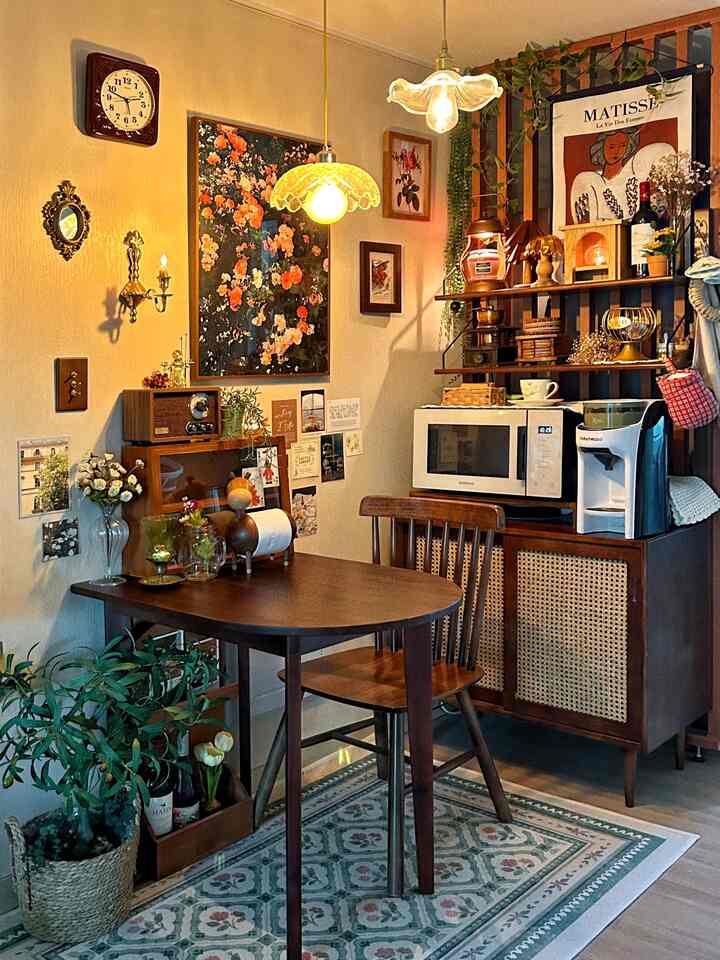 暖かいブラウンの木目調とヴィンテージ小物があるコンパクトなダイニング、半円形の木製テーブルとヴィンテージのペンダントライトが配置された印象的な空間