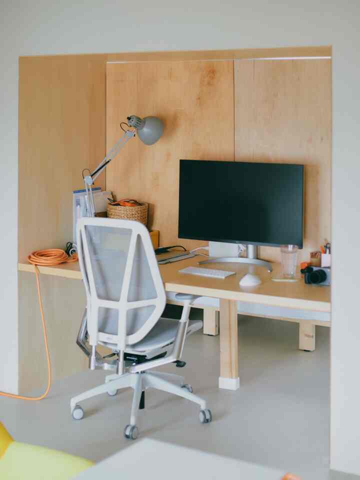ナチュラルカラーのホームオフィス、木製デスクと白いオフィスチェアが配置された整然とした作業空間
