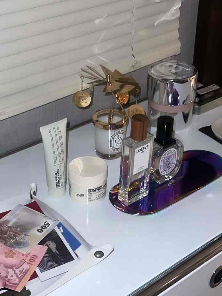 White-toned vanity surface featuring candles and perfumes arranged neatly in a clean space