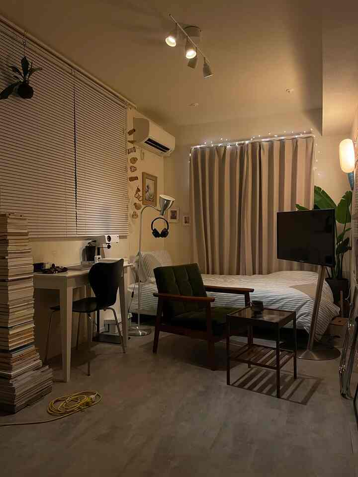 ナチュラルカラーの寝室、デスクとナイトテーブル、間接照明が配置された雰囲気のあるインテリア