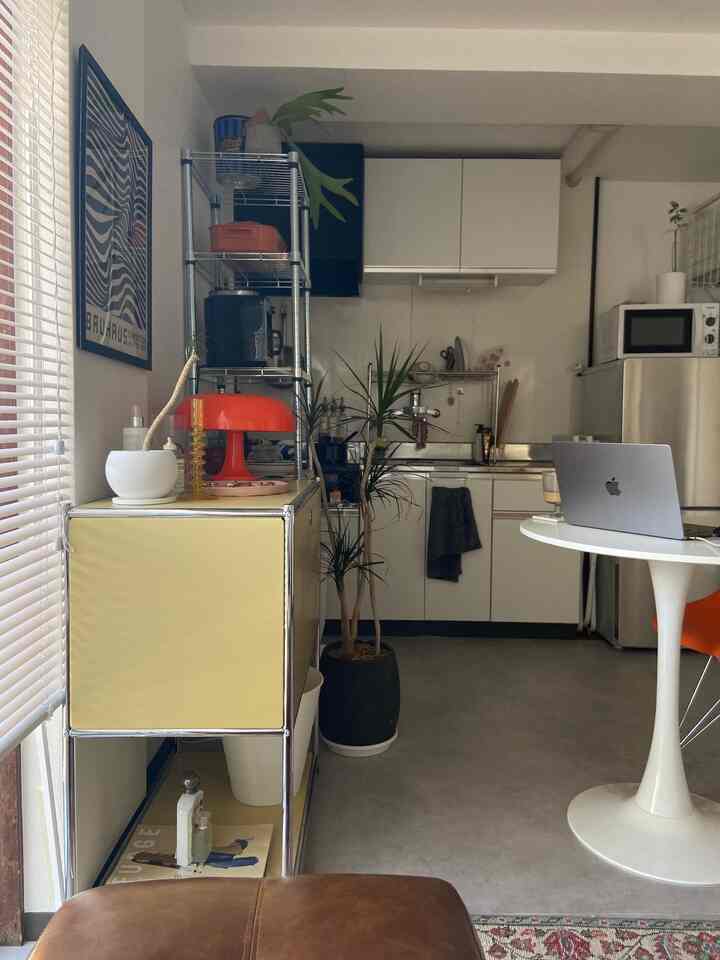 White and brown toned 1DK kitchen with remote work setup, featuring mid-century modern furniture and decor in a compact space