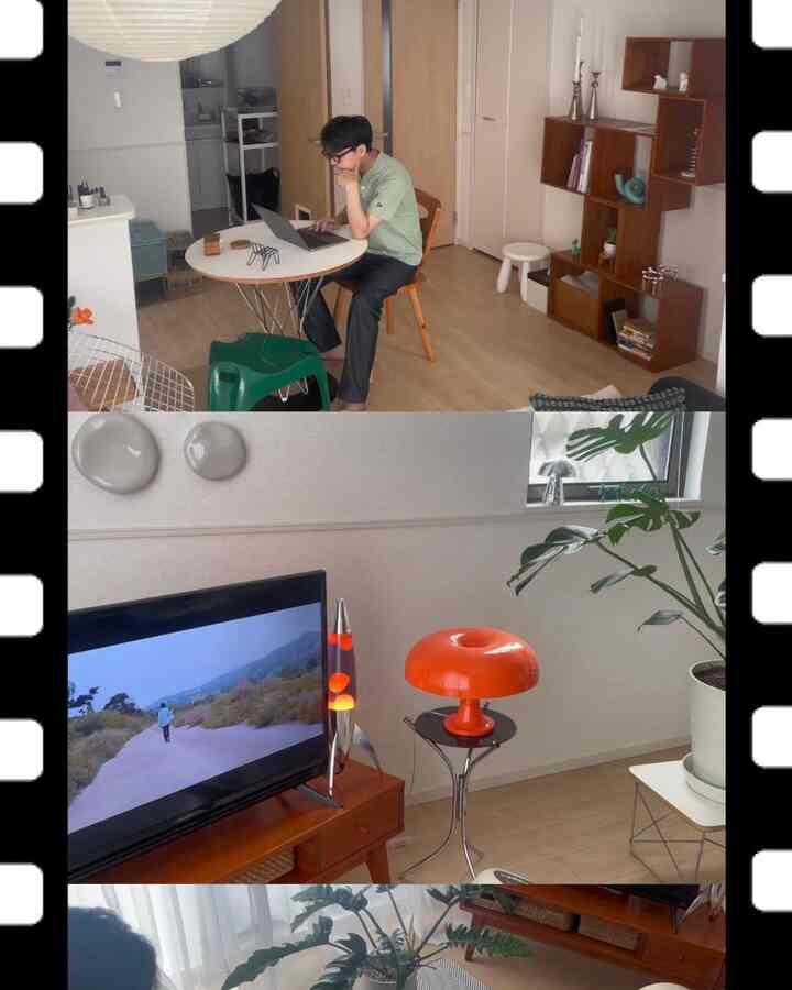 ナチュラルな木目調と白い壁のリビング兼ホームオフィス、緑の植物とヴィンテージ照明が調和した雰囲気のある空間