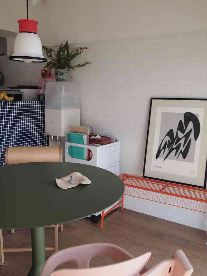 Cafe style dining room with white tiled walls and an olive green round dining table
