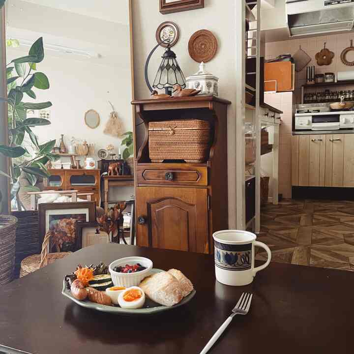 Natural tone kitchen and dining table featuring vintage furniture and wall art in a cozy space