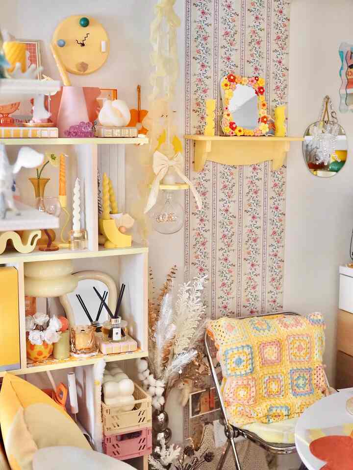 黄色のトーンのリビング、木製棚と多彩な装飾品が配置された雰囲気のあるインテリア