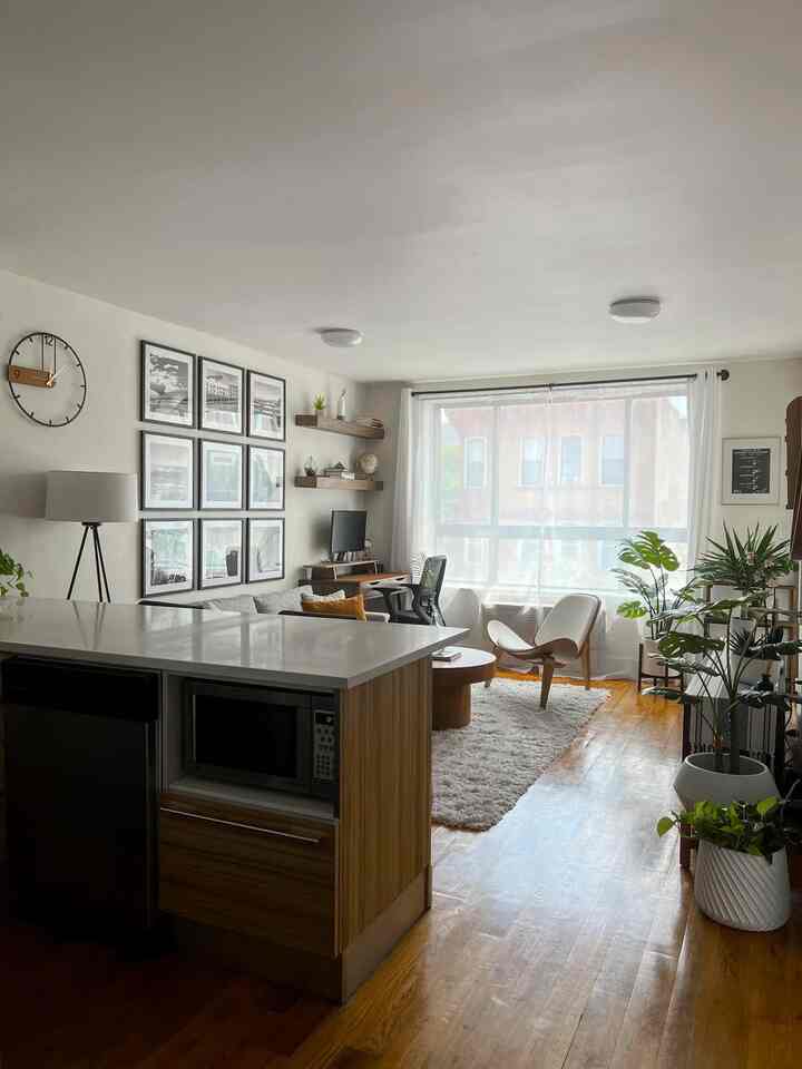 White and wood tone living room featuring mid-century modern chair and floor lamp with cozy atmosphere