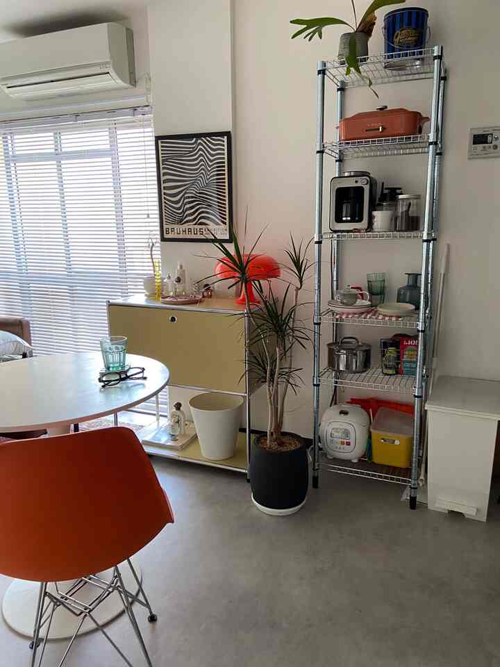 Yellow cabinet and orange dining chair in a 1DK living room, featuring Mid-Century Modern style with cozy atmosphere