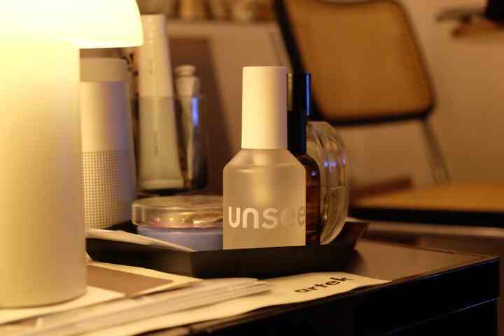 温かみのある照明とナチュラルカラーの家具が配置されたワンルーム空間のテーブル上に置かれたHAYのトレイと照明小物