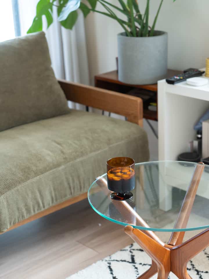 Natural color and transparent glass tabletop define a two-person living room with a cozy, compact atmosphere