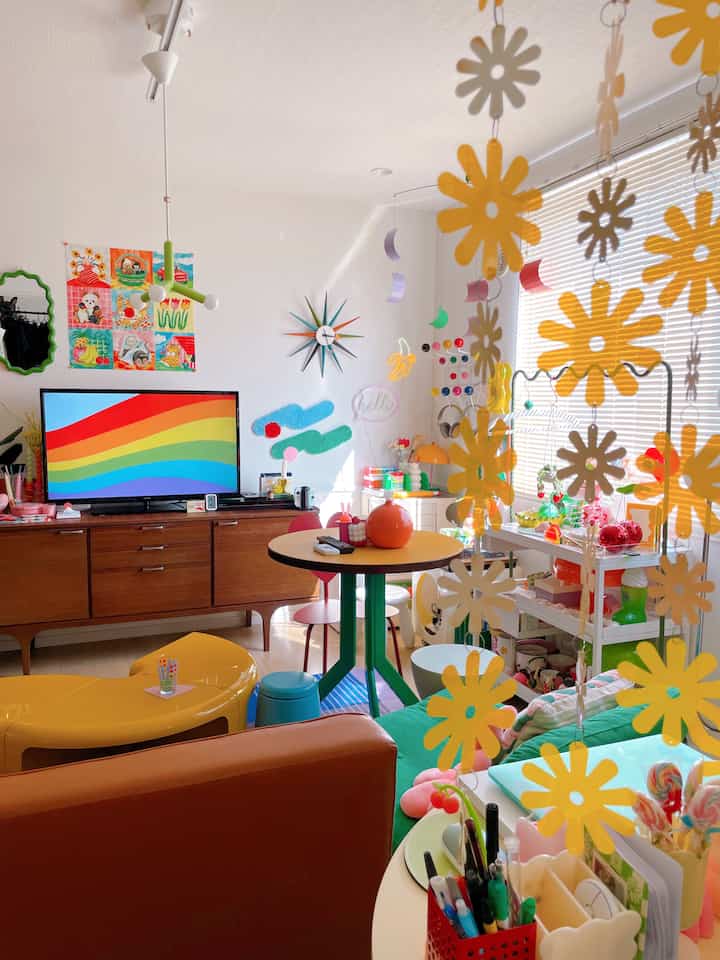 黄色と緑の色調が特徴のダイニング、レトロな丸テーブルとペンダントライト、個性的な装飾がある雰囲気のあるインテリア