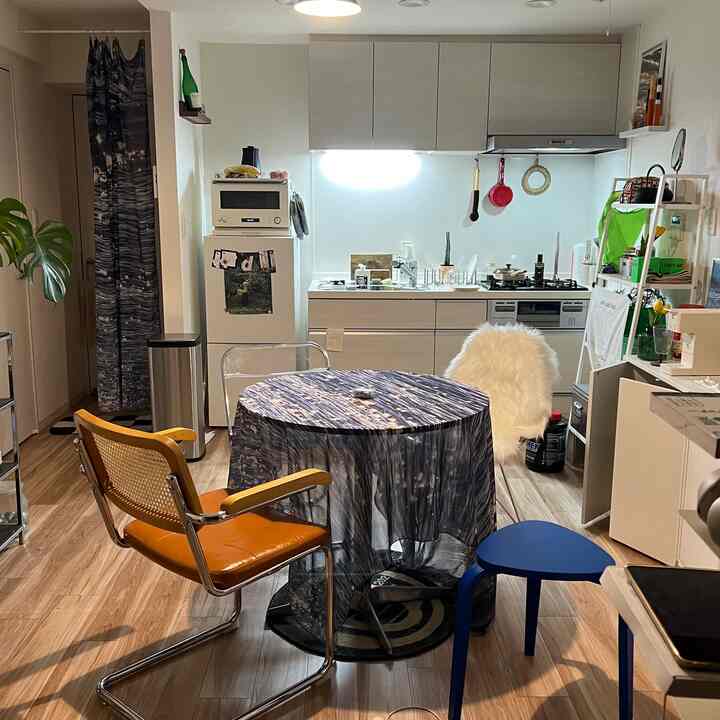 Light gray and white kitchen dining room featuring a round table with fabric tablecloth, creating a modern and natural atmosphere
