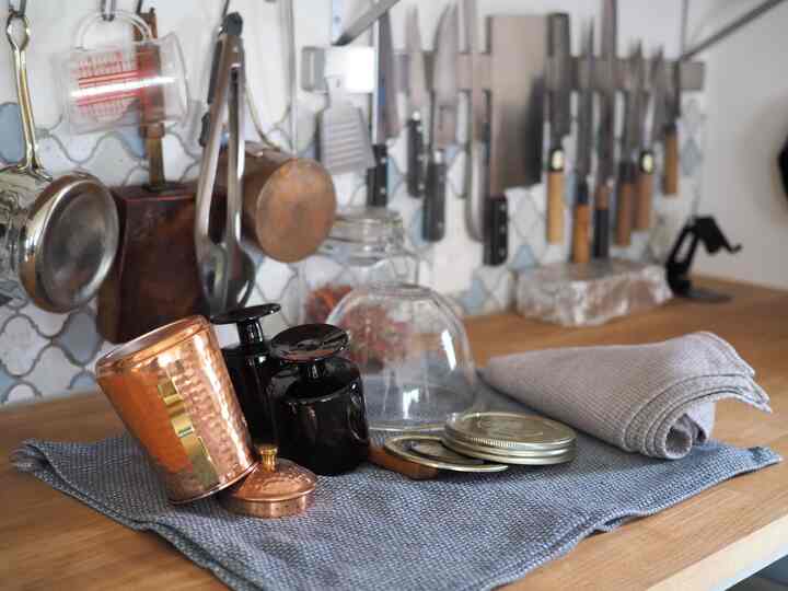 Natural color kitchen featuring wooden countertop and neatly arranged kitchen utensils with a clean atmosphere