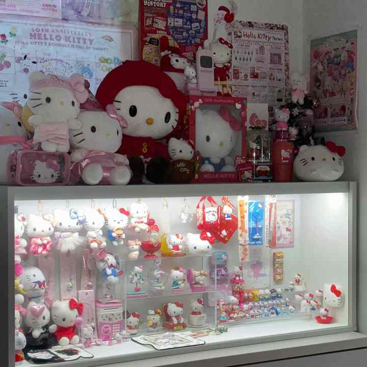 ピンクと白の色調の寝室キティゾーン、様々なハローキティのぬいぐるみとコレクションが配置された雰囲気のあるインテリア