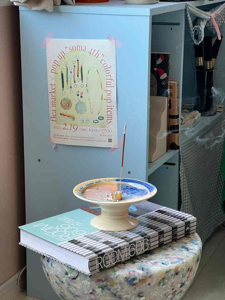 Pastel blue cabinet and multicolor speckled stool with a plate holding incense creating cozy interior corner