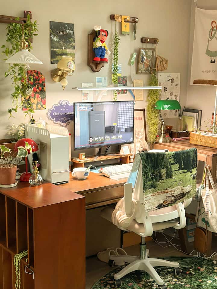 木目調とヴィンテージ感のあるホームオフィス空間、デスクとオフィスチェア、壁の装飾や植物が調和した温かみのあるインテリア