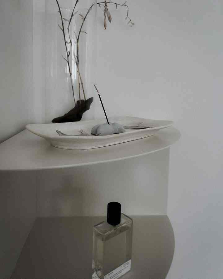 白を基調としたコーナー棚、陶器とドライフラワーのオブジェが配置されたシンプルでナチュラルな雰囲気のあるインテリア