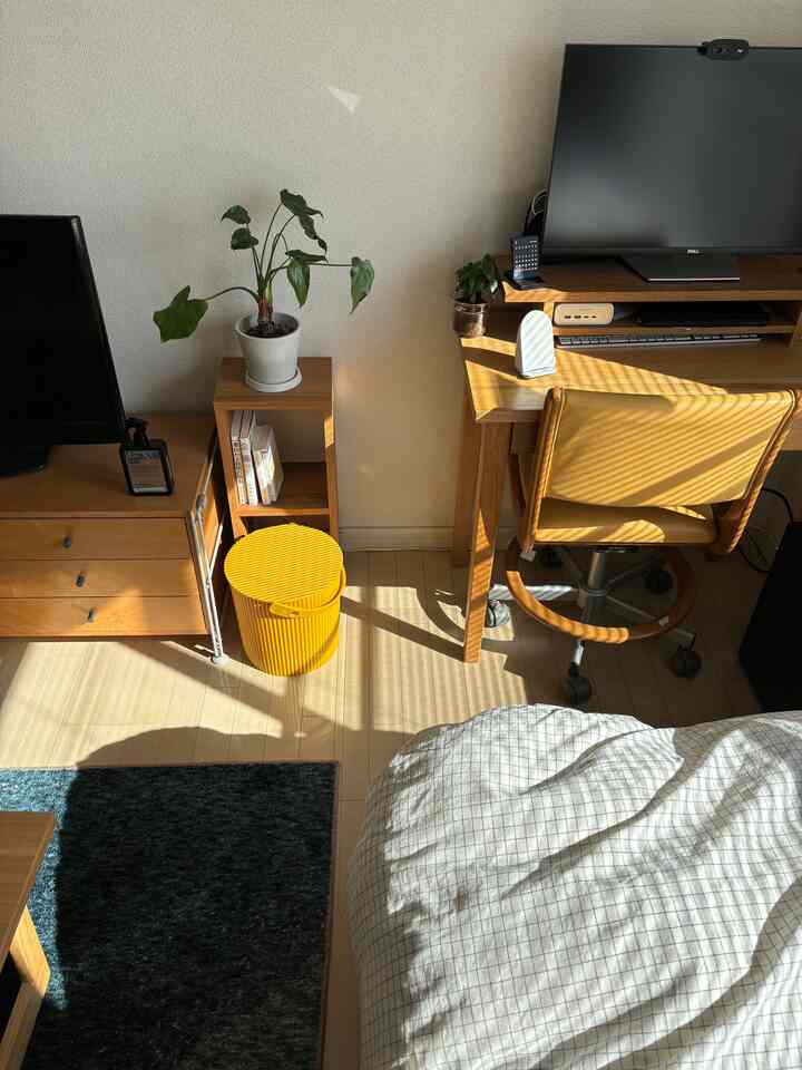 Yellow and natural-toned 1K bedroom featuring a desk, stool, and bed in a cozy Nordic style space