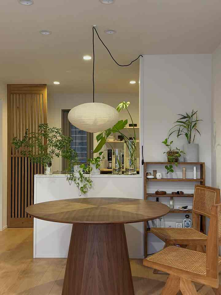 Natural wood tones and white walls define the dining room featuring a round table and rattan chairs with a cozy atmosphere