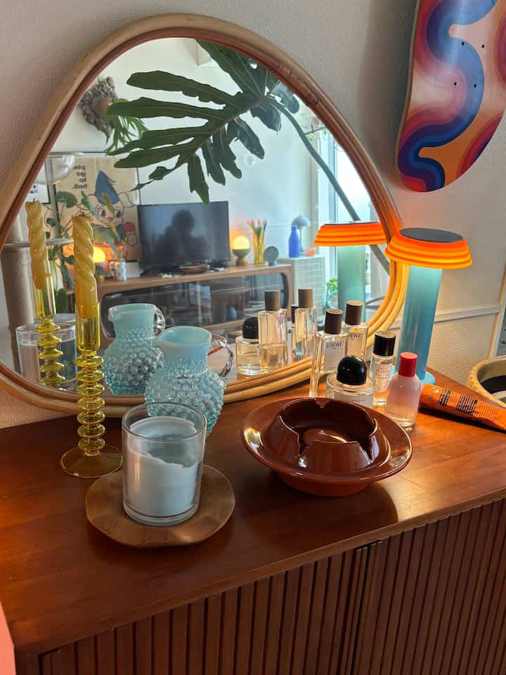 Warm brown-toned living room featuring mid-century modern furniture, cat-related items, and plant stand with harmonious decor