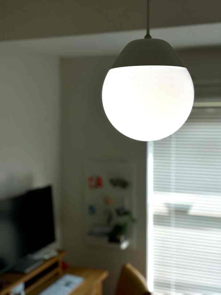 White and wood-toned 1K single household bedroom featuring a pendant light as focal point, creating a cozy atmosphere
