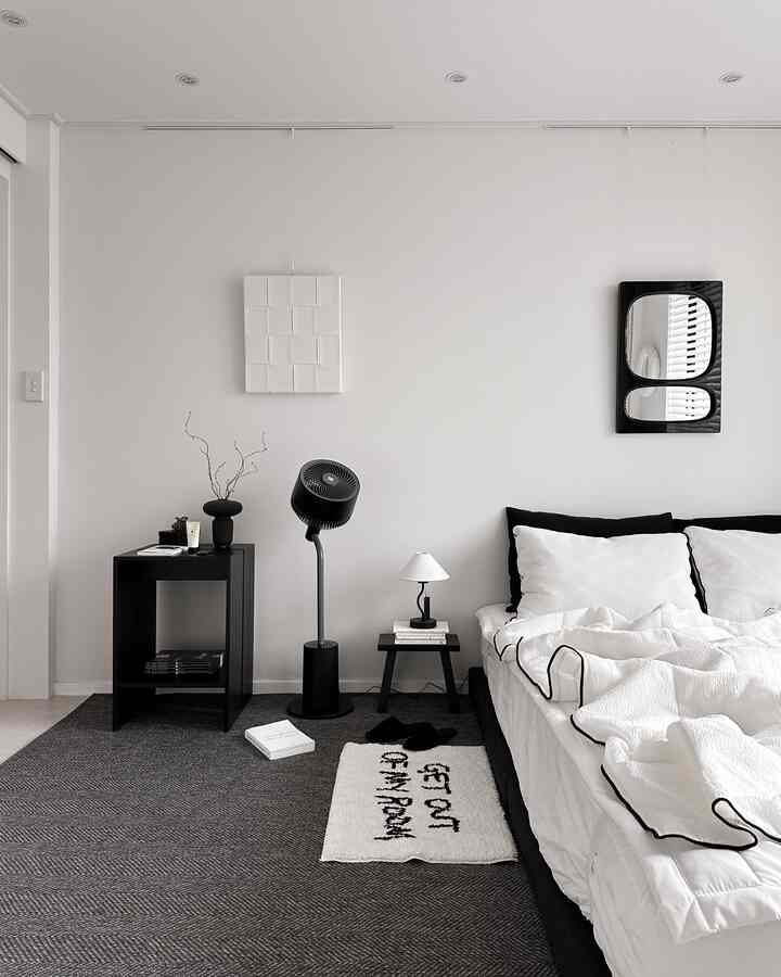 モノトーンの寝室、黒い家具と白い寝具が調和した清潔感のあるモダンなインテリア
