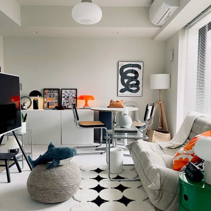 White and beige toned 2K living and dining space featuring mid-century modern furniture and a plush shark as a cozy accent