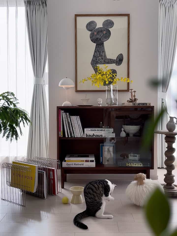 ホワイトとブラウンの色調のリビングルーム、ヴィンテージ本棚と猫が調和した清潔で温かみのあるインテリア