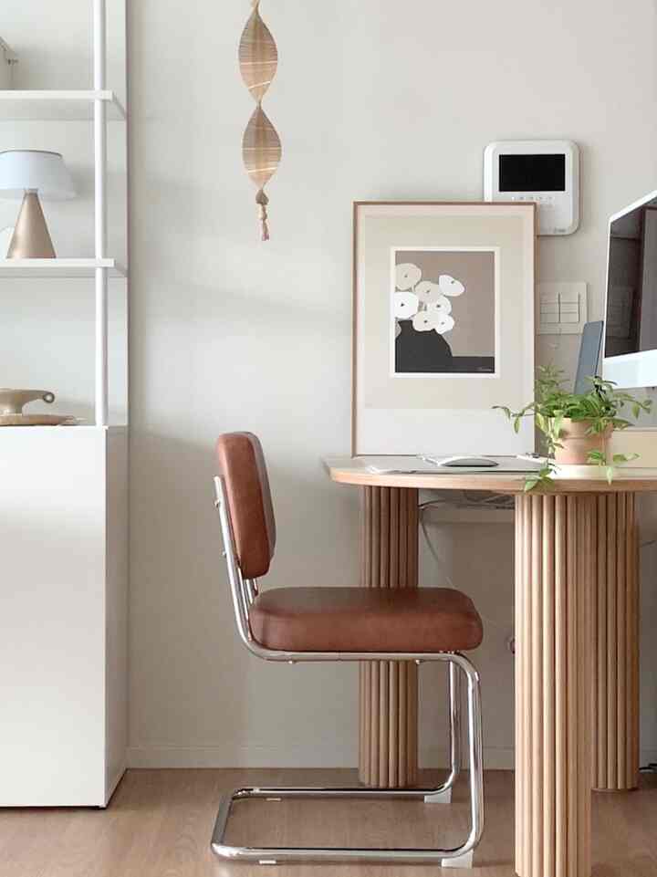 Natural and modern home office study featuring brown leather chair and wooden table