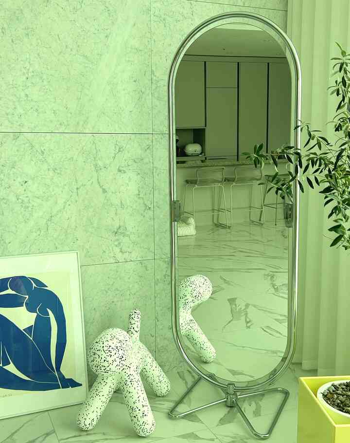 白とナチュラルカラーのリビングキッチン空間、ベアパンの全身鏡と独特なスツールが配置された清潔感のあるインテリア