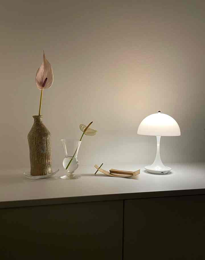 White-toned entrance shelf featuring minimalist vases and a glowing table lamp with a clean aesthetic