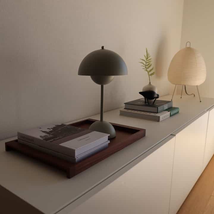 White-toned sideboard featuring a wooden tray and table lamps in a simple and natural Nordic style interior